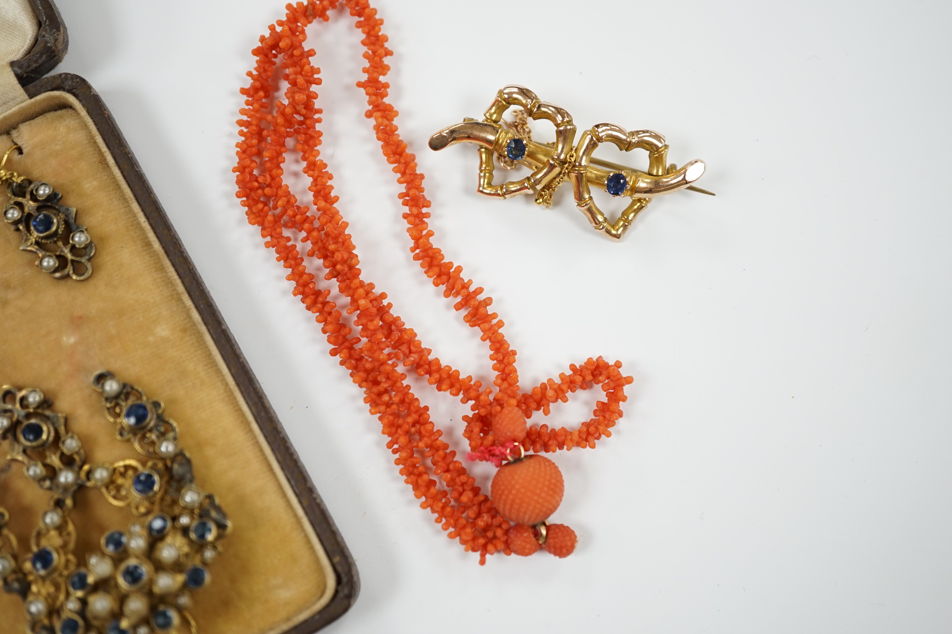 A suite of gilt metal and paste set jewellery, comprising a necklace and pair of earrings, a late Victorian 9ct gold and two stone sapphire set twin hearts brooch and a coral necklace.